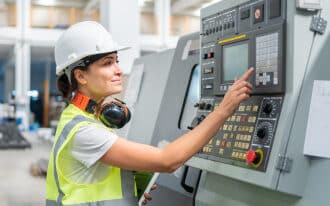 female industrial engineer pressing buttons on machinery